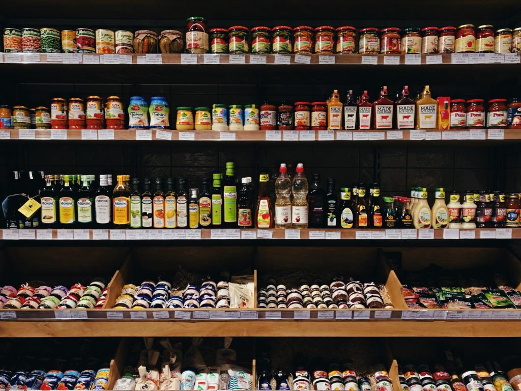 Busy grocery store shelves with oils and other items.