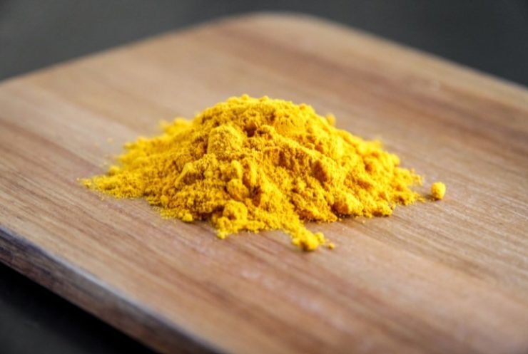 ground turmeric on a wooden cutting board